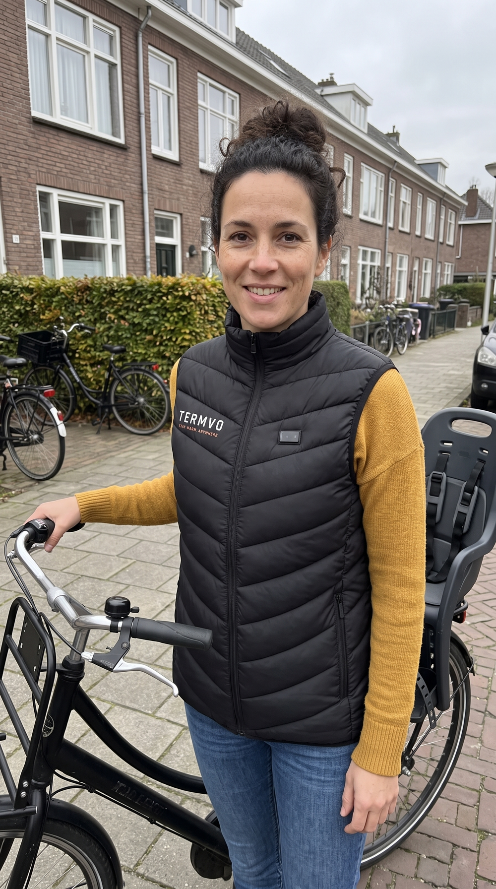 Vrouw met fiets in een verwarmde TERMVO bodywarmer